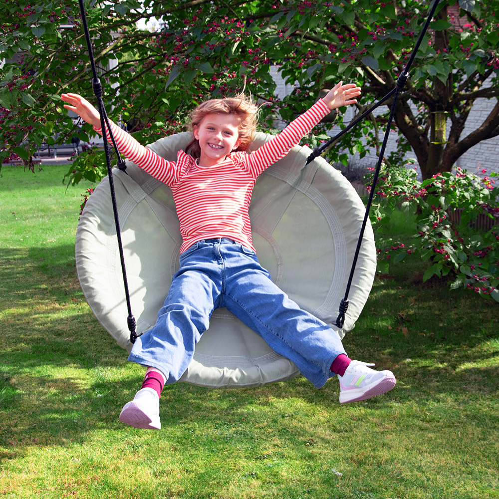 Vogelnestschaukel pastellgrün ein Kind schaukelt auf einer Vogelnestschaukel